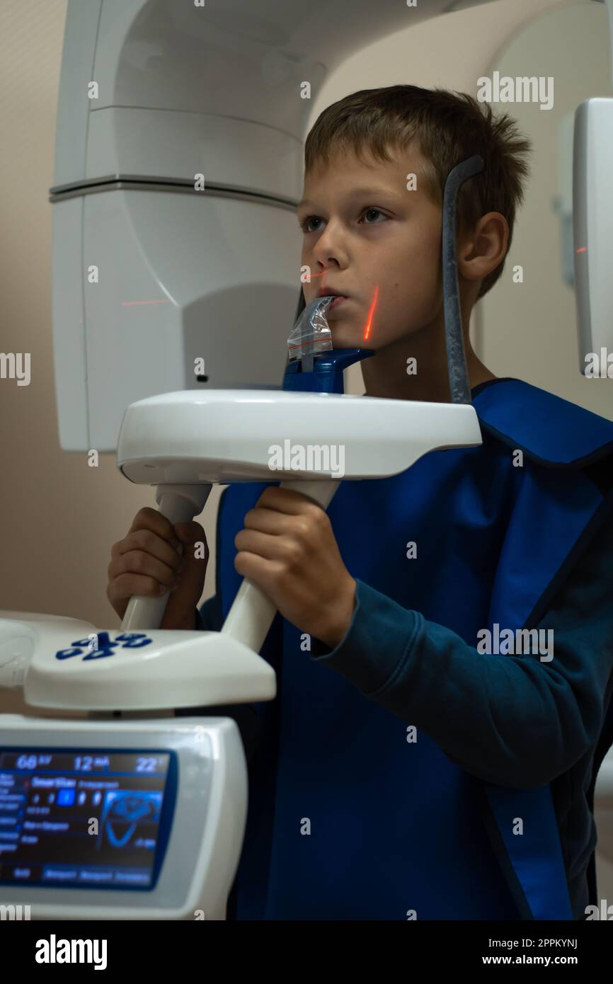 Jaw computed tomography, check up teeth in dental clinic. Little boy on x-ray diagnostics. Circular snapshot of jaw. Stock Photo