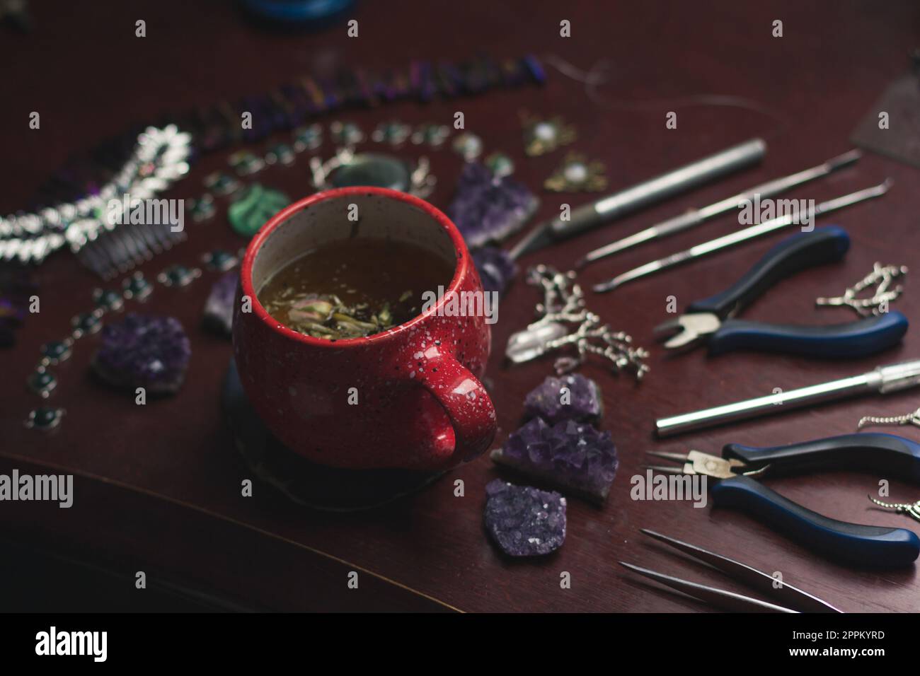 Close up jewelry maker herbal tea cup and tools concept photo Stock Photo