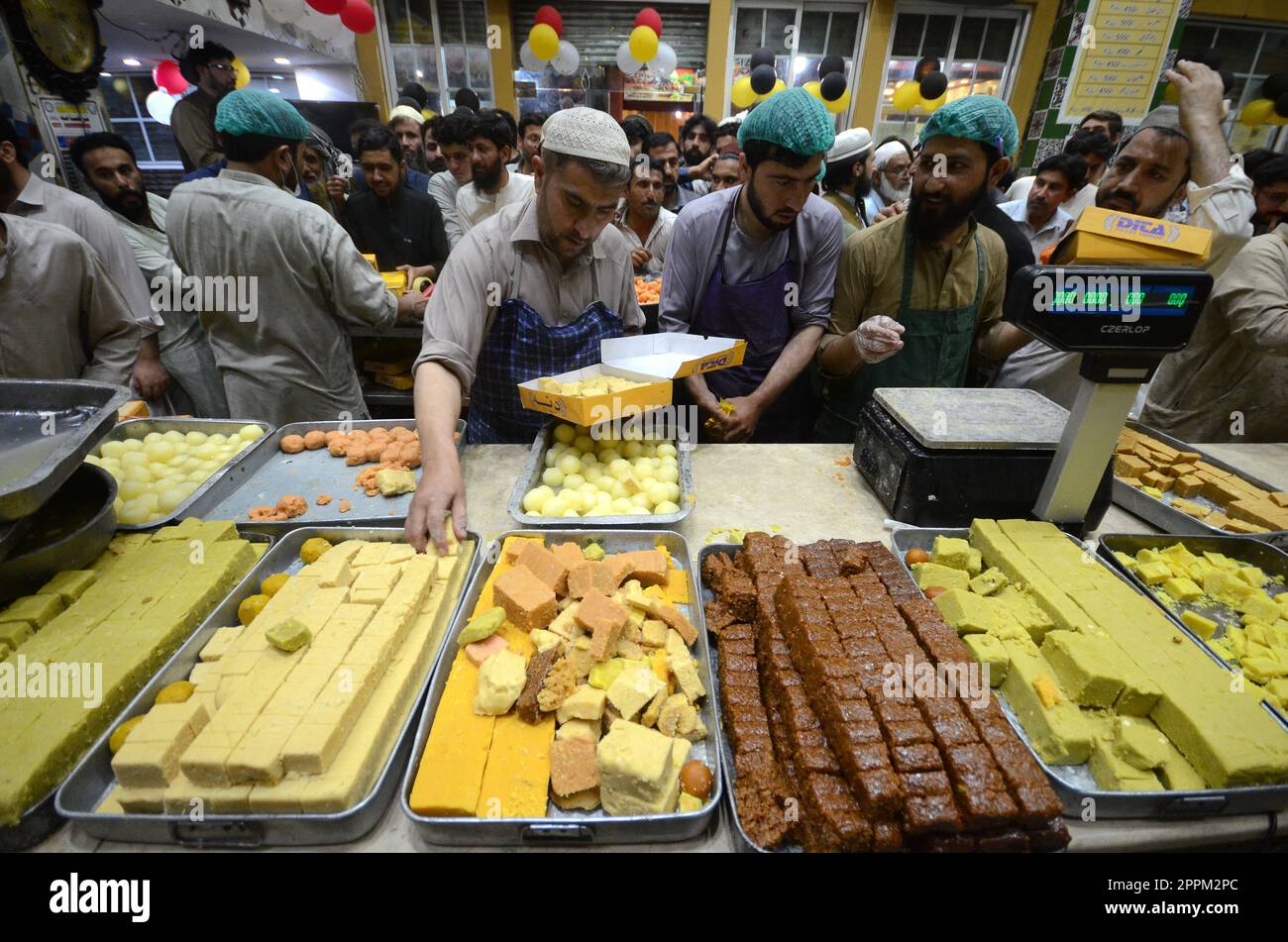 Peshawar, Pakistan. 20th Apr, 2023. People buy traditional sweets in ...