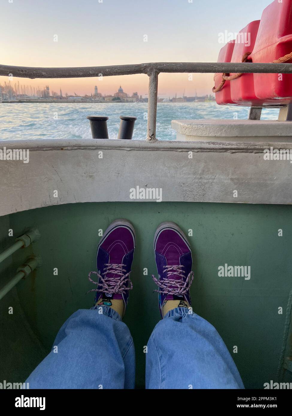 tourist in Vans sneakers leaves city on water bus Stock Photo