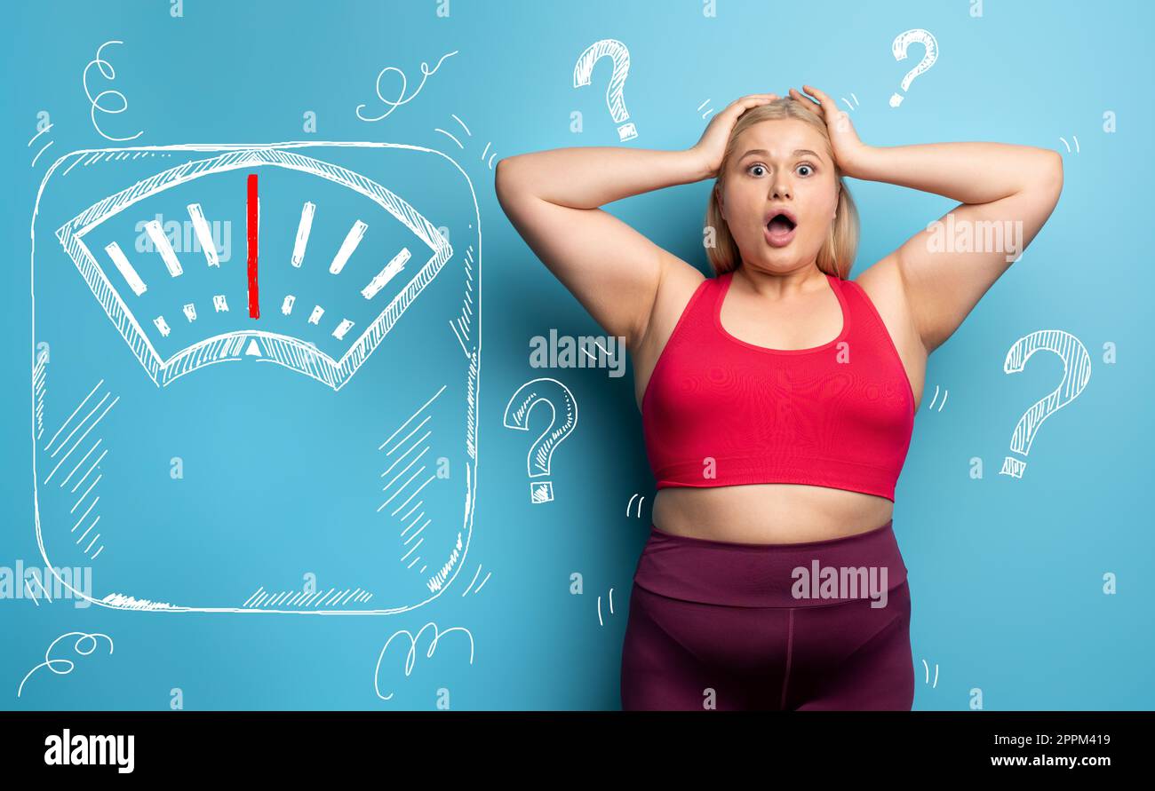 Fat girl is worried because the scale marks a high weight. Cyan background Stock Photo
