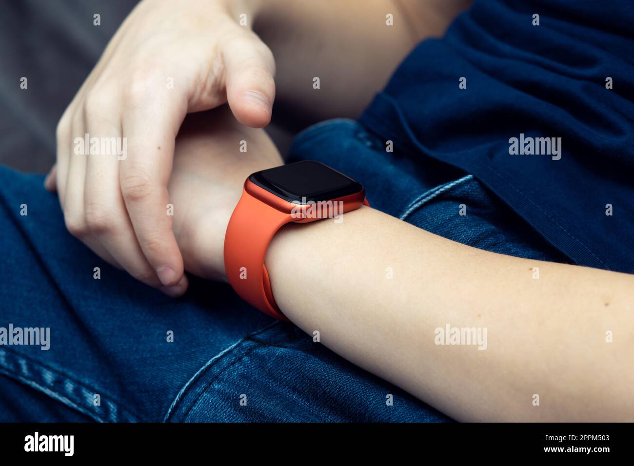 Red stylish smart watch on male wrist closeup. Touch finger on empty screen of wearable gadget to look time and data Stock Photo Alamy