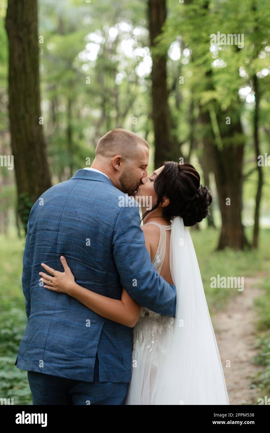 wedding walk of the bride and groom in the deciduous forest in summer Stock Photo