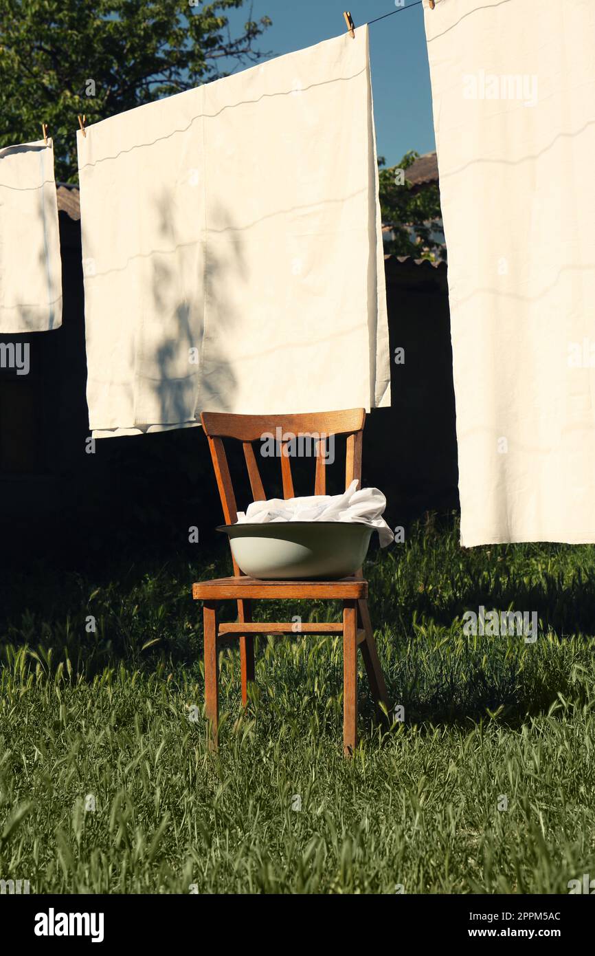 Washing line with clean laundry and clothespins outdoors Stock Photo