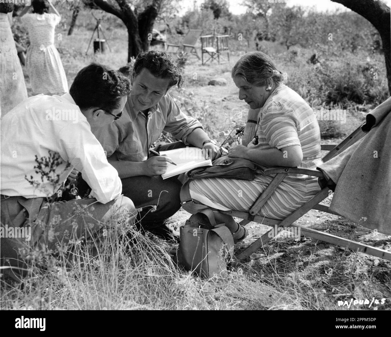 PETER USTINOV discusses a costume sketch with his mother Costume Designer NADIA BENOIS on set location candid in Central Italy during filming of PRIVATE ANGELO 1949 directors / producers / screenplay MICHAEL ANDERSON and PETER USTINOV novel Eric Linklater costume design Nadia Benois Pilgrim Pictures / Associated British-Pathe Stock Photo