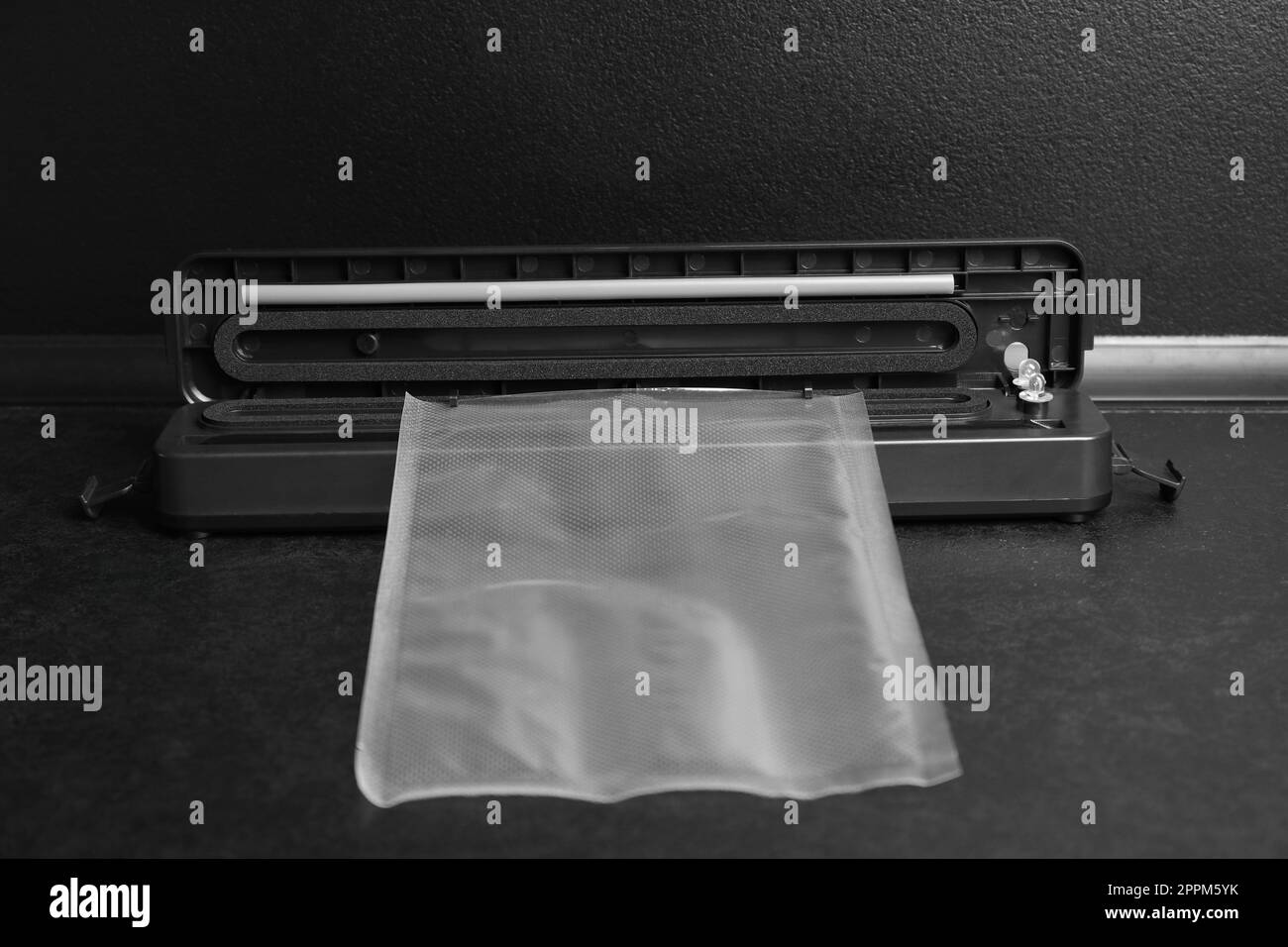 Sealer for vacuum packing with plastic bag on black table Stock Photo