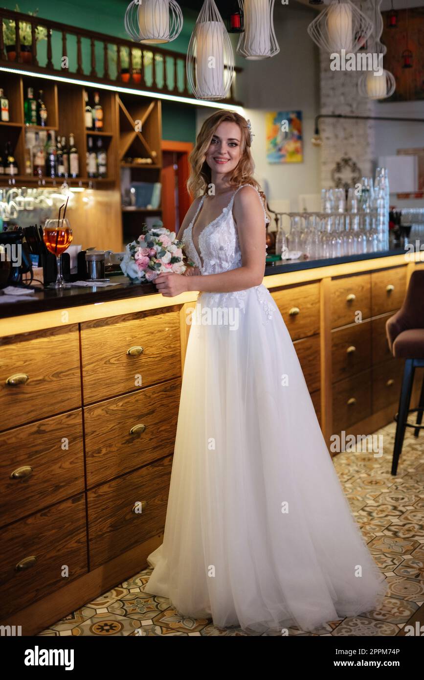 blonde bride in a bar near with a wedding bouquet Stock Photo