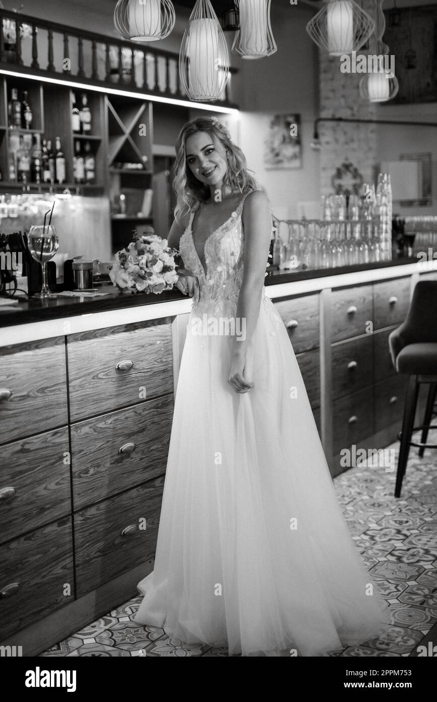 blonde bride in a bar near with a wedding bouquet Stock Photo