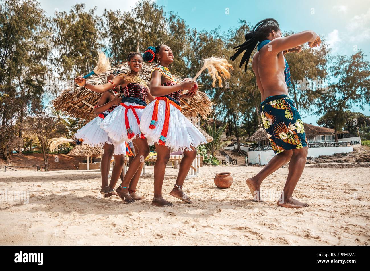 Kenyan people dance on the beach with typical local clothes Stock Photo