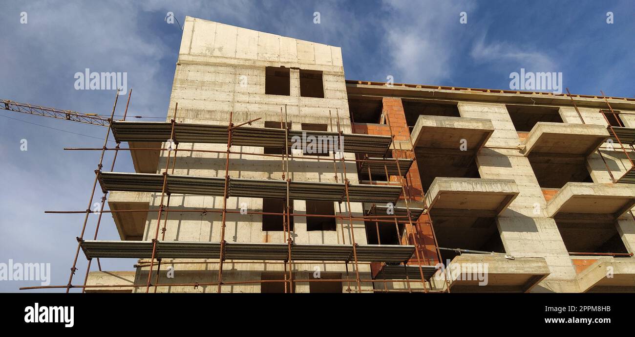 Construction of a quarter of five-story houses made of monolithic concrete. Industry, construction, real estate. Building facade, scaffolding. New construction technologies for earthquake-prone areas. Stock Photo