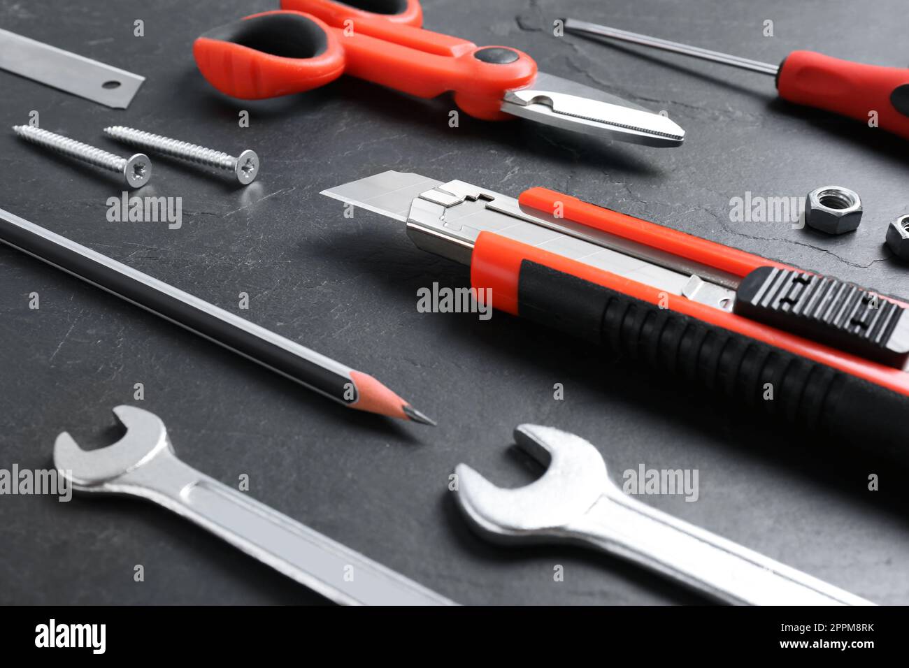 Utility knife and different tools on black table, closeup Stock Photo ...