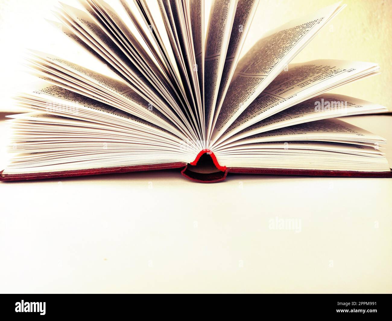 the opened book on the white table Stock Photo - Alamy