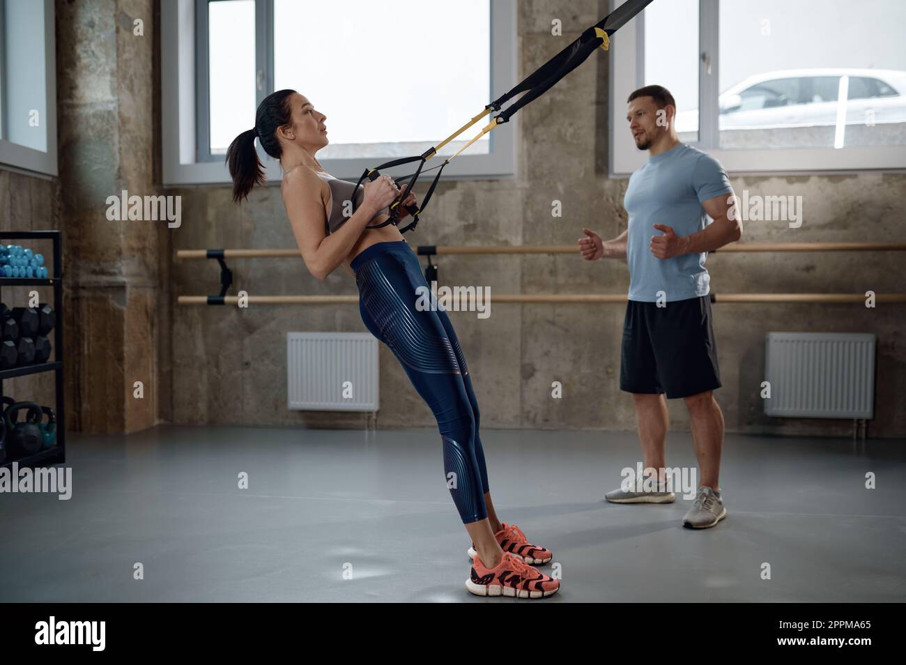 Woman training with suspension straps under professional sport coach control Stock Photo