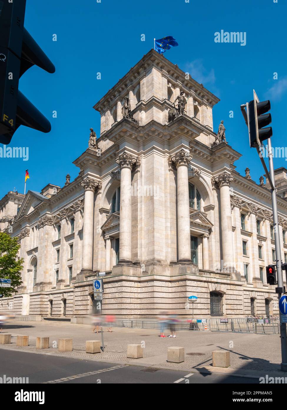 Bundestag Berlin Building, side view with traffic lights and people walking in front, long exposure, during summer with clear sky, vertical shot Stock Photo