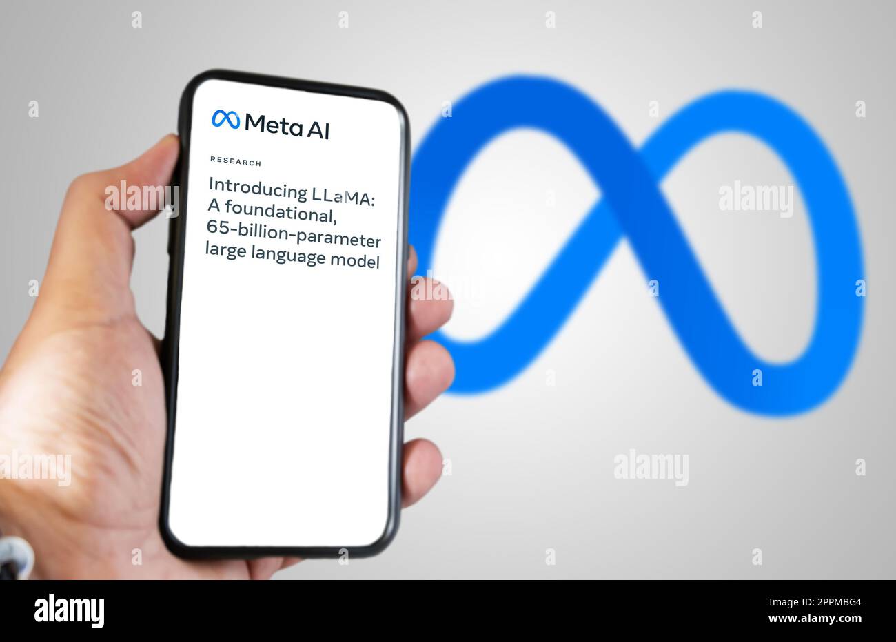hand holding a phone with Meta AI LLaMa news on the screen Stock Photo
