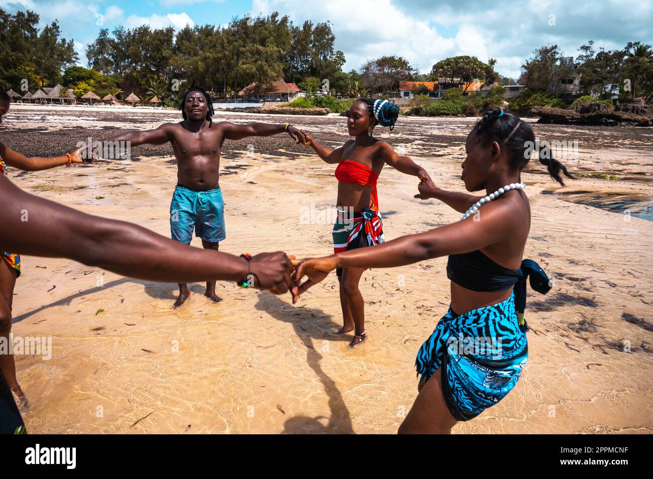 Kenyan people dance on the beach with typical local clothes Stock Photo