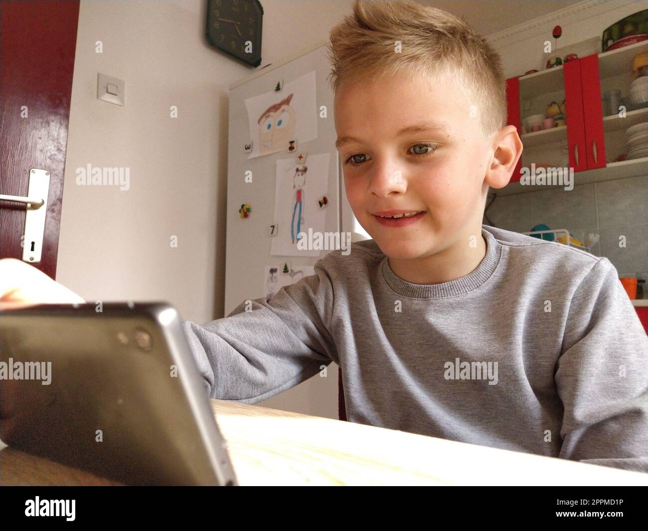 Sremska Mitrovica, Serbia, May 20, 2020 Blond boy with laptop. The child looks at the monitor. The emotion of joy Stock Photo