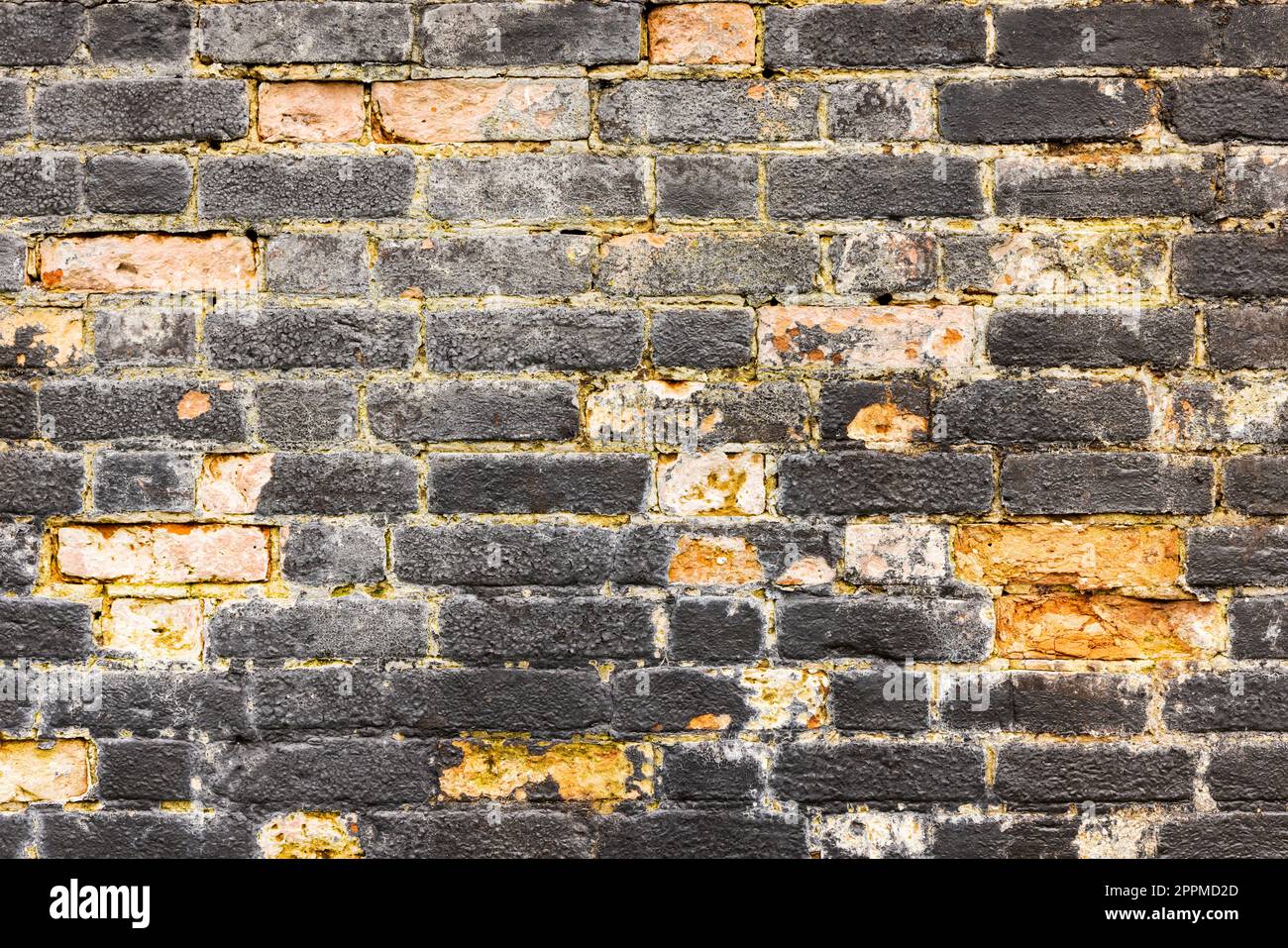 Old and worn black brick wall. Background texture. Stock Photo
