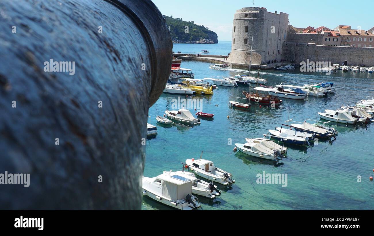 Dubrovnik, Croatia, 08.14. 2022. City port summer tourist attraction. Tourists walk, get into boats and ships and go on boat trips. Adriatic Sea. Travel. Cannon muzzle. Private boats of local citizens Stock Photo