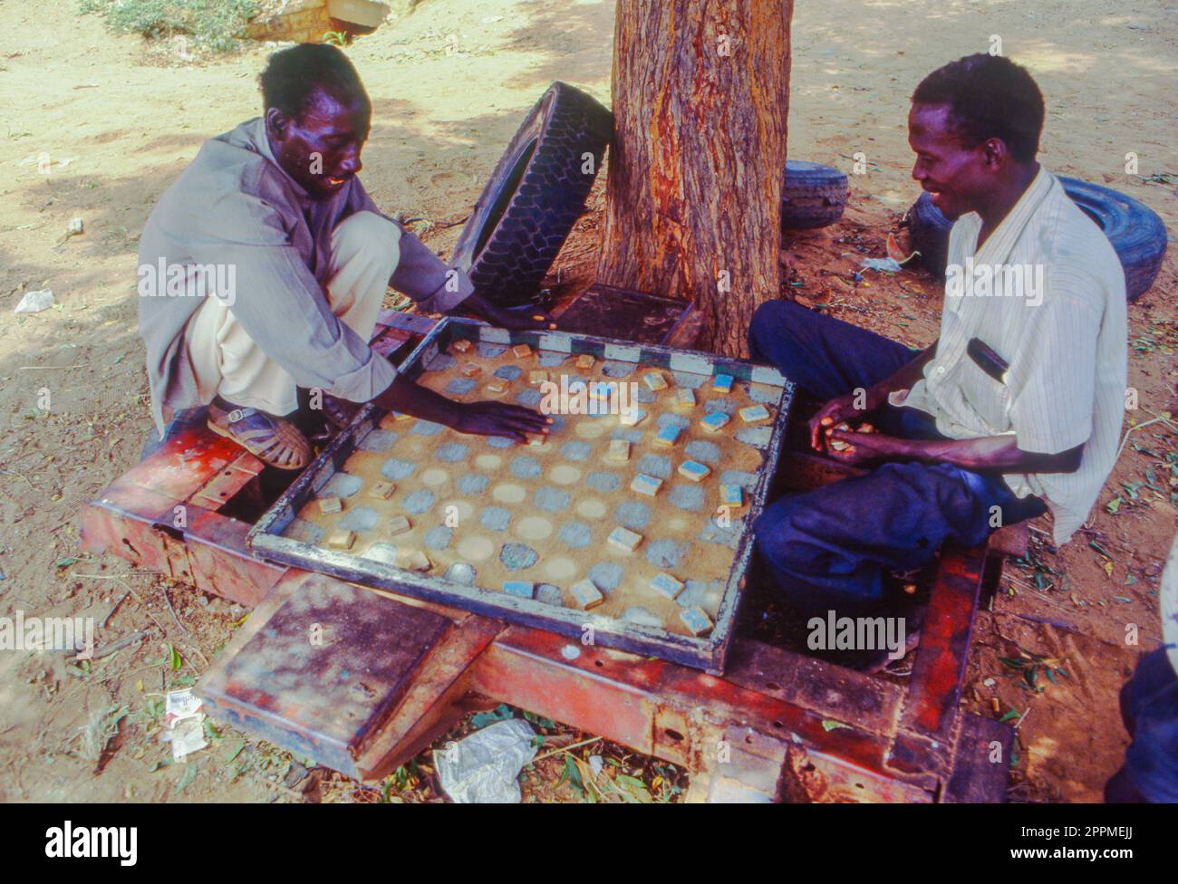 Senegal, Bambay, men are playing checkers under a tree. Stock Photo