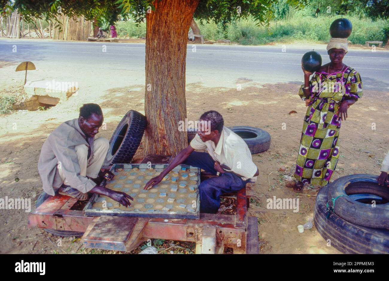 Senegal, Bambay, men are playing checkers under a tree. Stock Photo