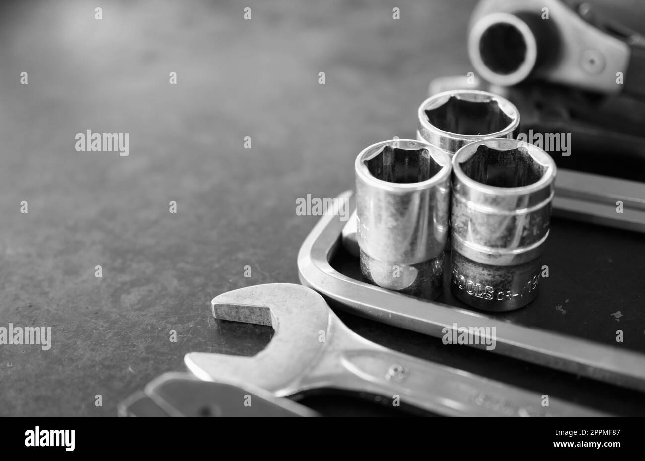 Hand tools consisting of wrenches, pliers, socket wrenches, laid out on old steel plate background. Stock Photo