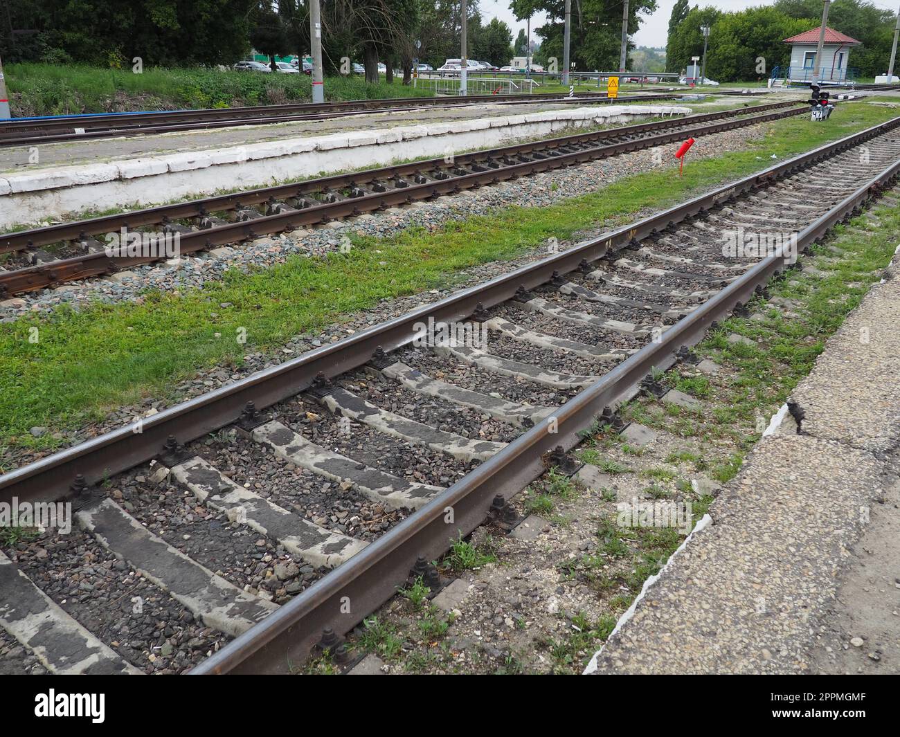 Usman, Lipetsk region, Russia August 7, 2021. Railway crossing. Rails, sleepers, traffic control point. The cars are waiting for the the movement. Traffic light red. Railway equipment and signs Stock Photo