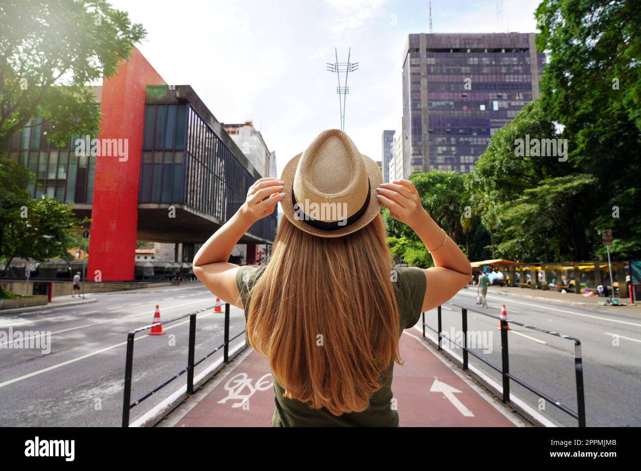 Tourism in Sao Paulo. Back view of beautiful traveler girl with hat walking on the Paulista Avenue, Sao Paulo, Brazil. Stock Photo