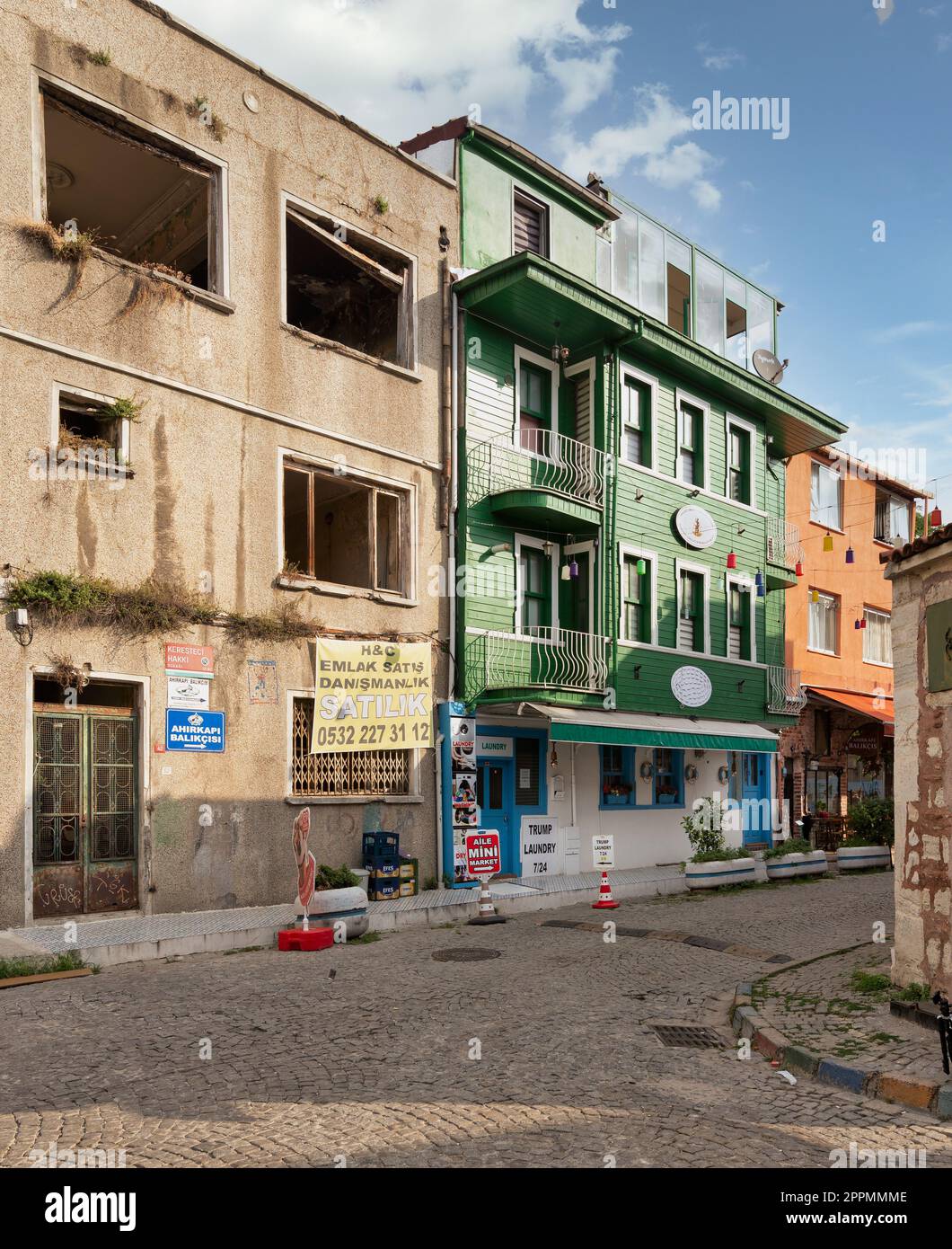 Cobblestone alley, with beautiful old houses painted in green and orange, suited in Fatih district, Istanbul Stock Photo