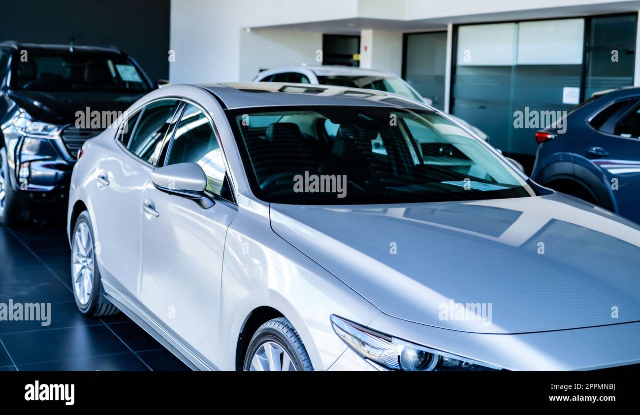 Car parked in luxury showroom. Car dealership office. New car parked in modern showroom. Car for sale and rent business concept. Automobile leasing and insurance concept. Electric vevicle for rent. Stock Photo