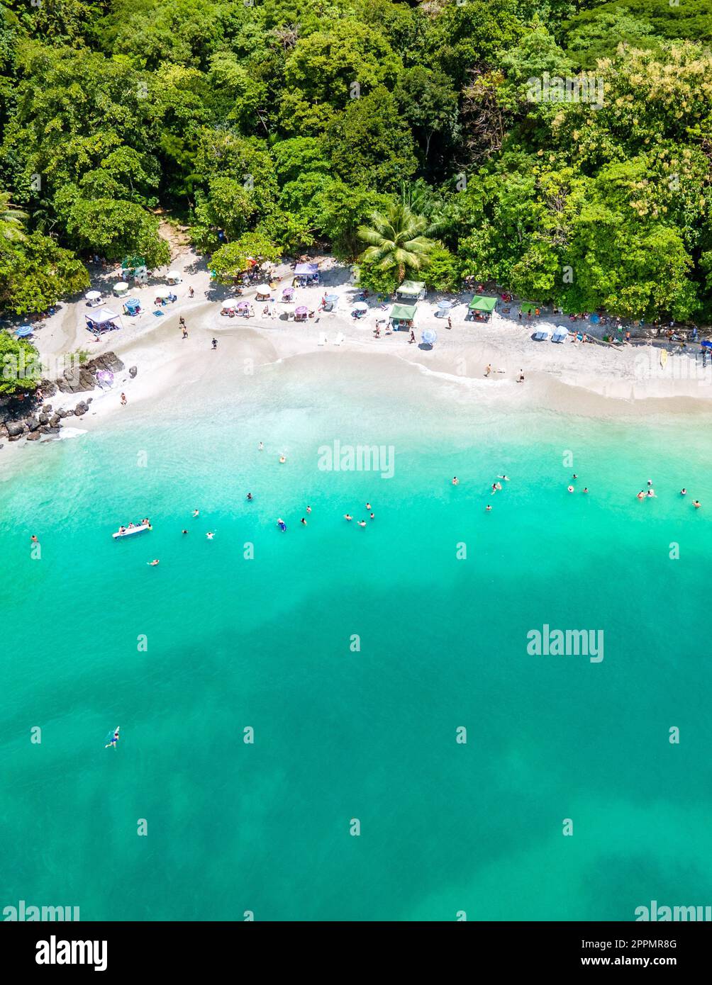 Aerial View From Flying Drone Of People Crowd Relaxing On Beach In Costa Rica Stock Photo