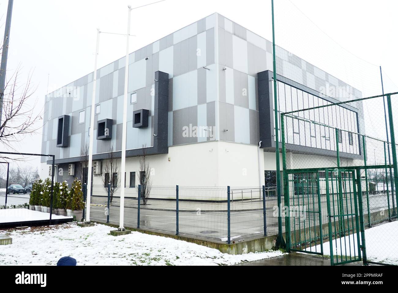 Sremska Mitrovica, Serbia, January 27, 2023 City swimming pool building. Pinky Swimming Pool, next to the Pinky Sports Centre. Modern sports building, gray and white ventilated facade. Snow in winter. Stock Photo