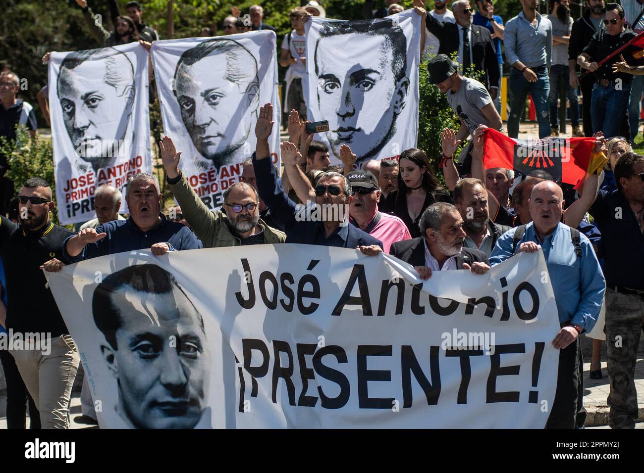 Madrid, Spain. 24th Apr, 2023. Members and supporters of La Falange party carrying banners raising hands making a fascist salute during a protest outside the San Isidro Cemetery the day of the exhumation of the remains of the founder of Falange, Jose Antonio Primo de Rivera. The fascist politician's remains were exhumed from the Valle de los Caidos (known now as Valle de Cuelgamuros) and transferred to the San Isidro cemetery. Credit: Marcos del Mazo/Alamy Live News Stock Photo