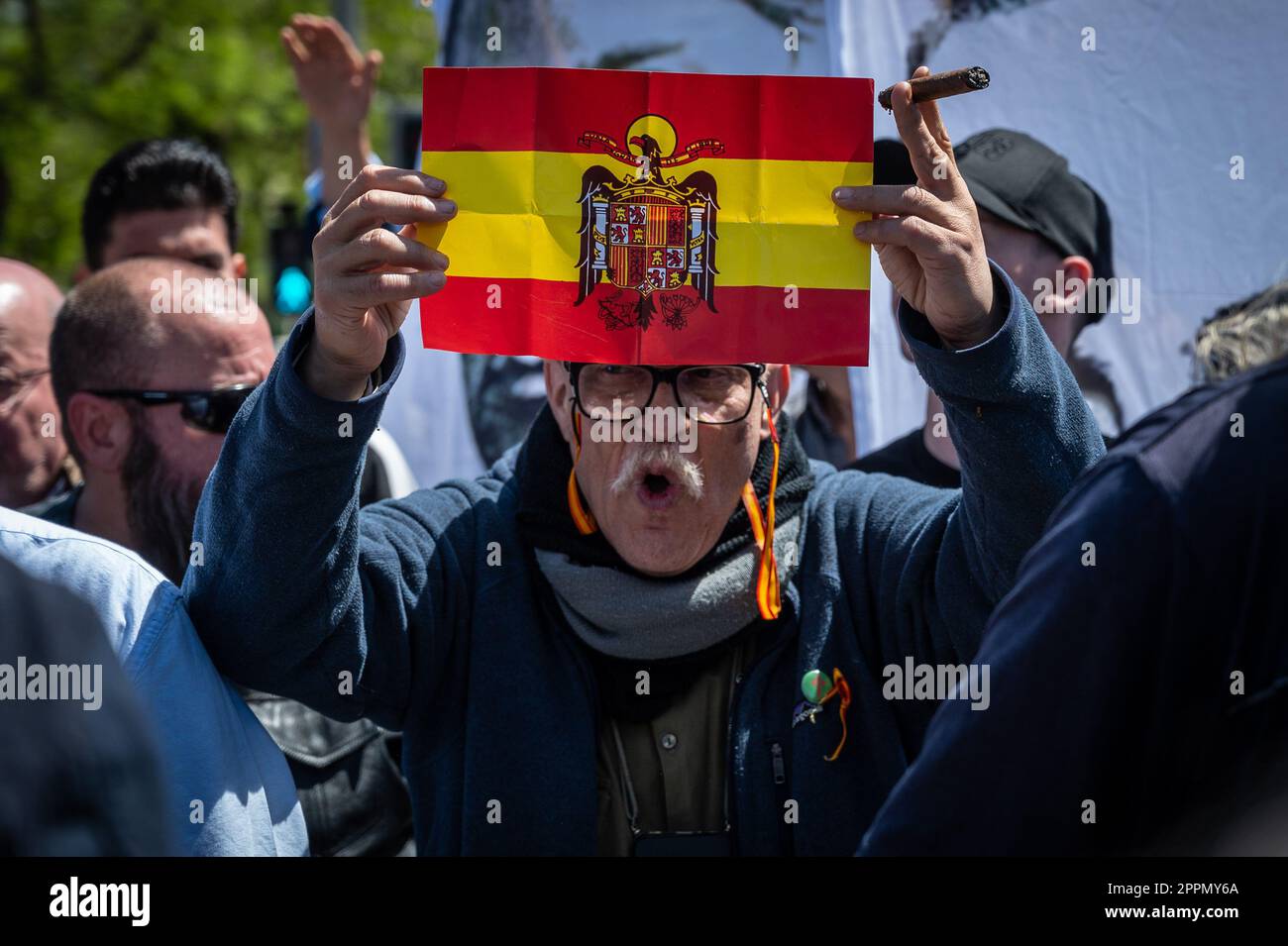 Madrid, Spain. 24th Apr, 2023. A man carrying a pre constitutional Spanish flag is seen during a protest in front of the San Isidro cemetery. Members and supporters of La Falange party have gathered to protest the day of the exhumation of the remains of the founder of Falange, Jose Antonio Primo de Rivera, the fascist politician's remains were exhumed from the Valle de los Caidos (known now as Valle de Cuelgamuros) and transferred to the San Isidro cemetery. Credit: Marcos del Mazo/Alamy Live News Stock Photo