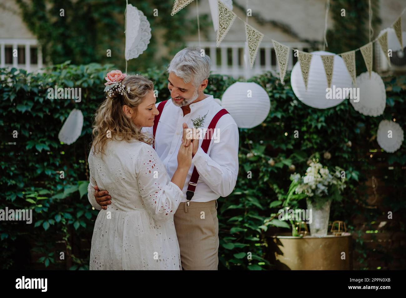 Close-up of bride and groom dancing at their outdoor wedding party ...