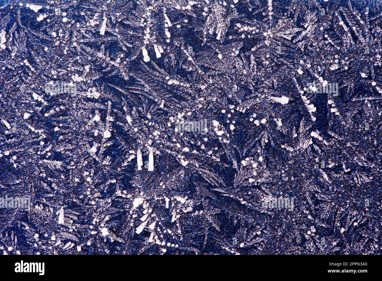 Abstract macro background with ice crystals on a blue metallic surface ...