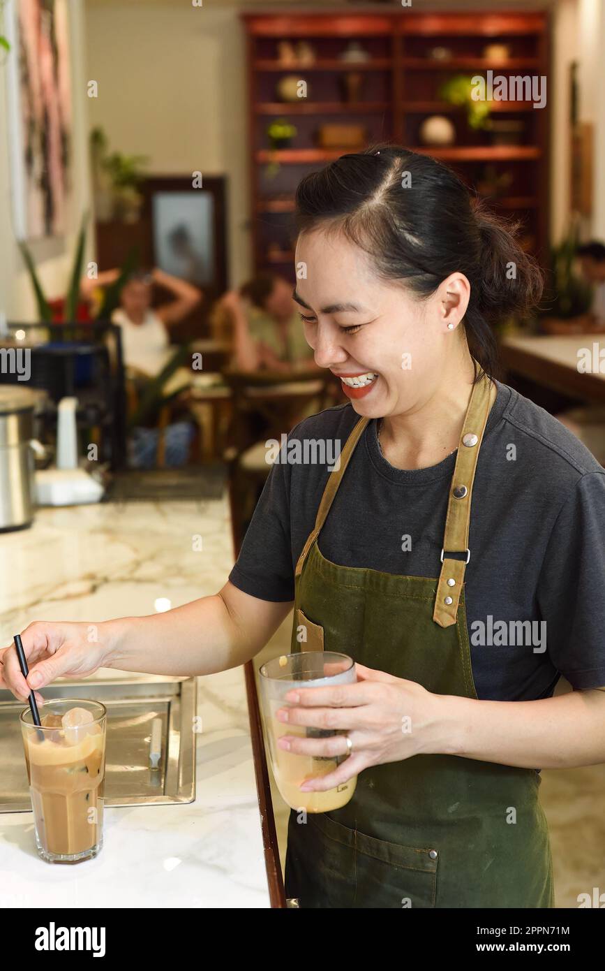 Vietnamese barista added ice and straw in vietnamese coffee Cafe Sua Stock Photo