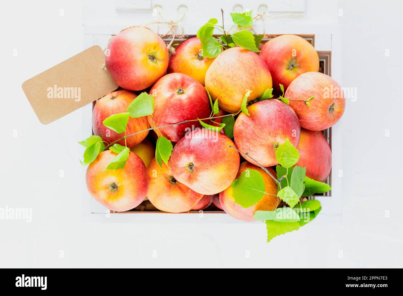 Natural red apples in wooden box with empty label Stock Photo - Alamy