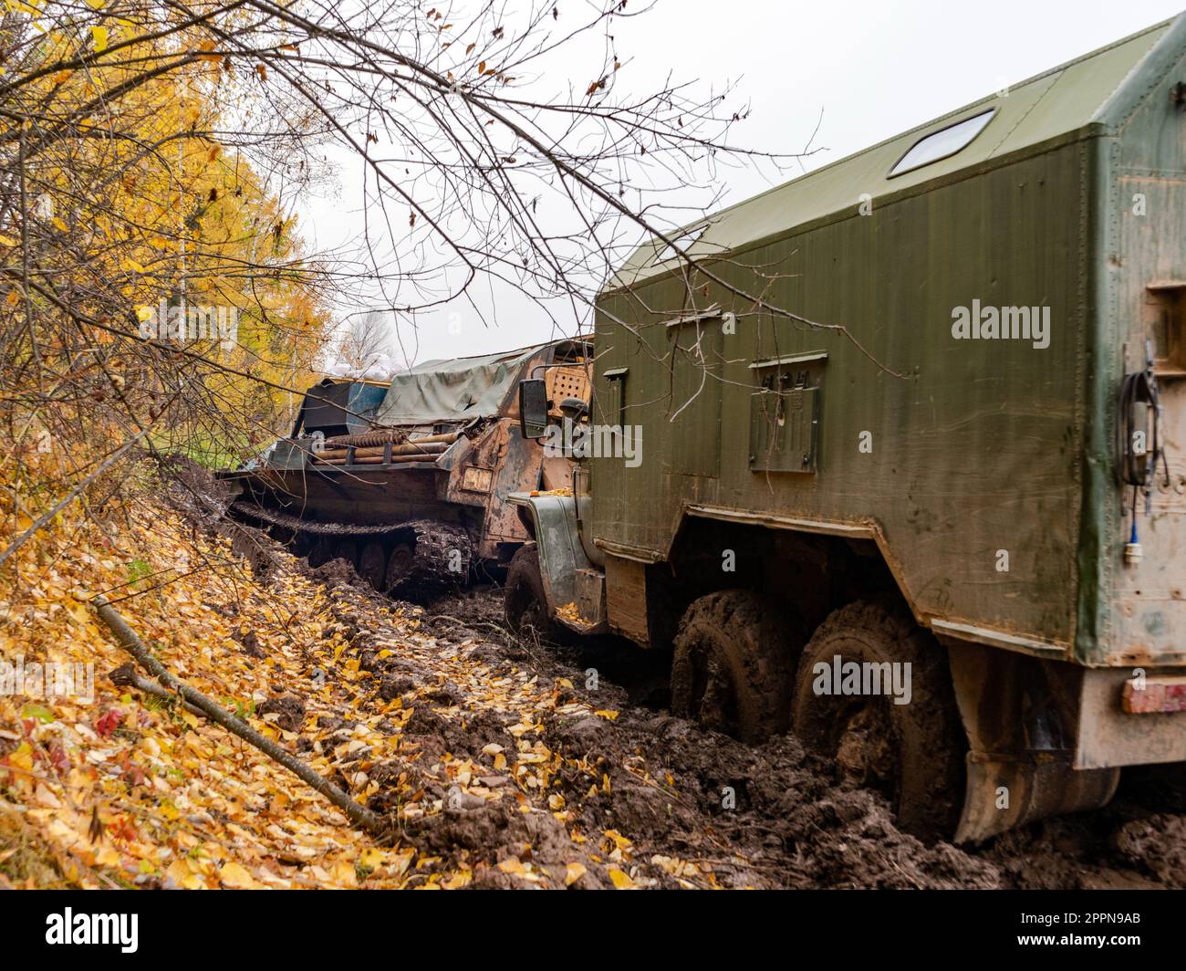 tracked vehicles pull a military truck out of the mud Stock Photo Alamy