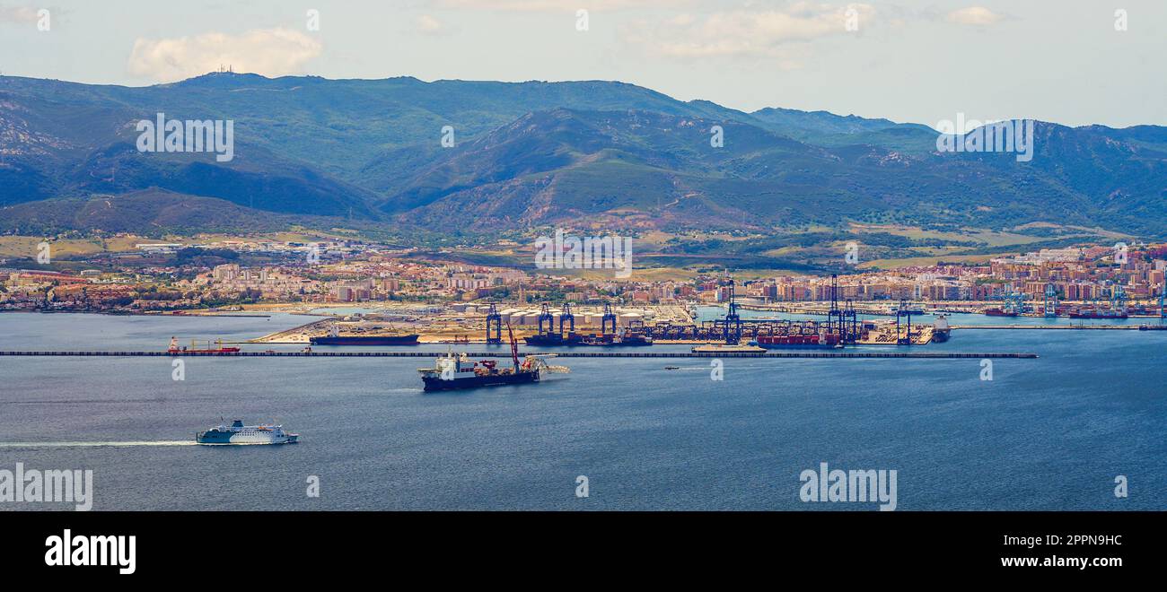 Panoramic view of the industrial port of Algésiras in the south of Spain - Giant cranes loading containers onto maritime freighters in the Mediterrane Stock Photo