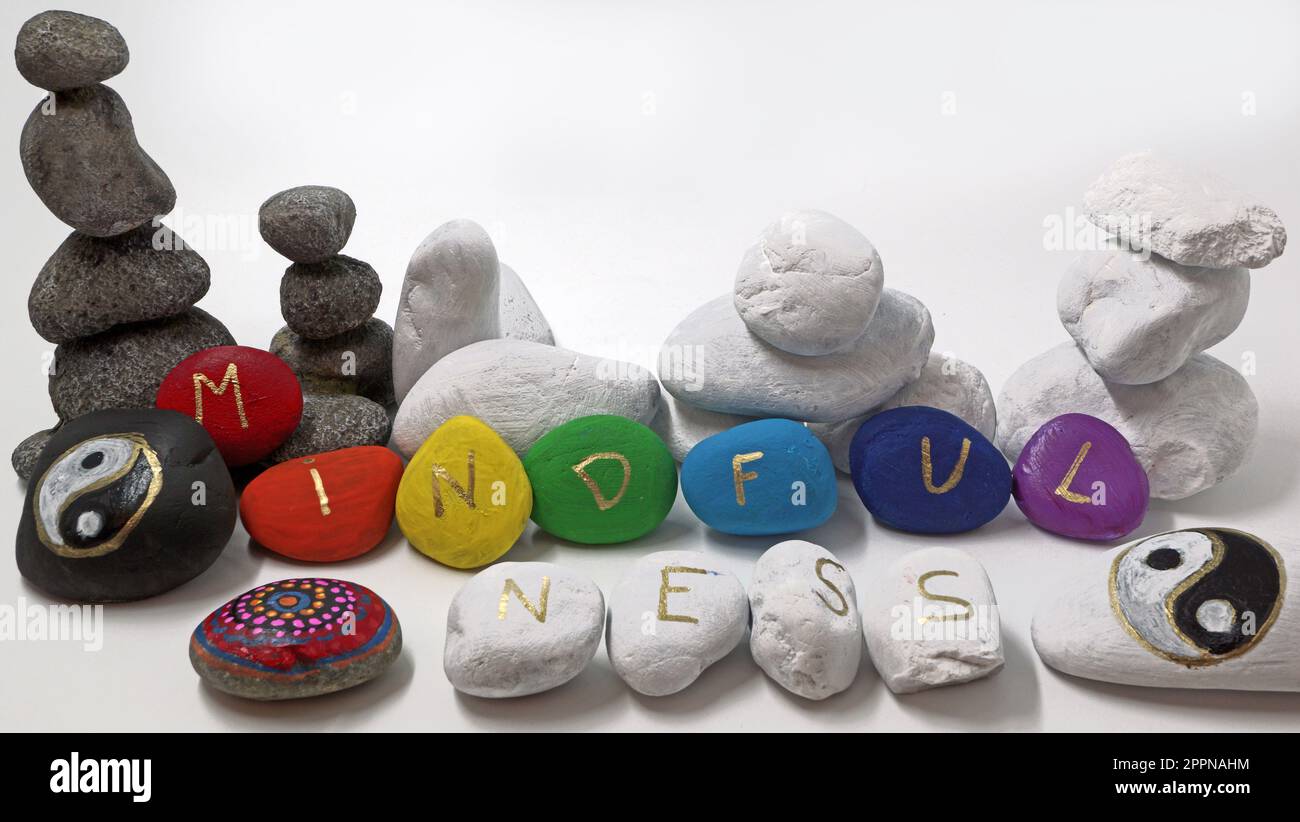 Mindfulness painted on colored stones with two yin yang stones. Rock painting Stock Photo