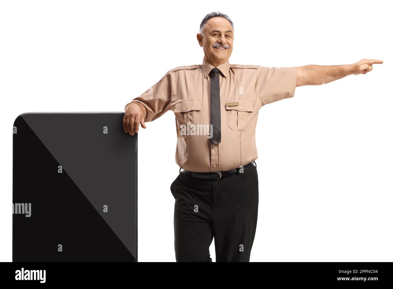 Security guard leaning on a big mobile phone and pointing to the side isolated on white background Stock Photo