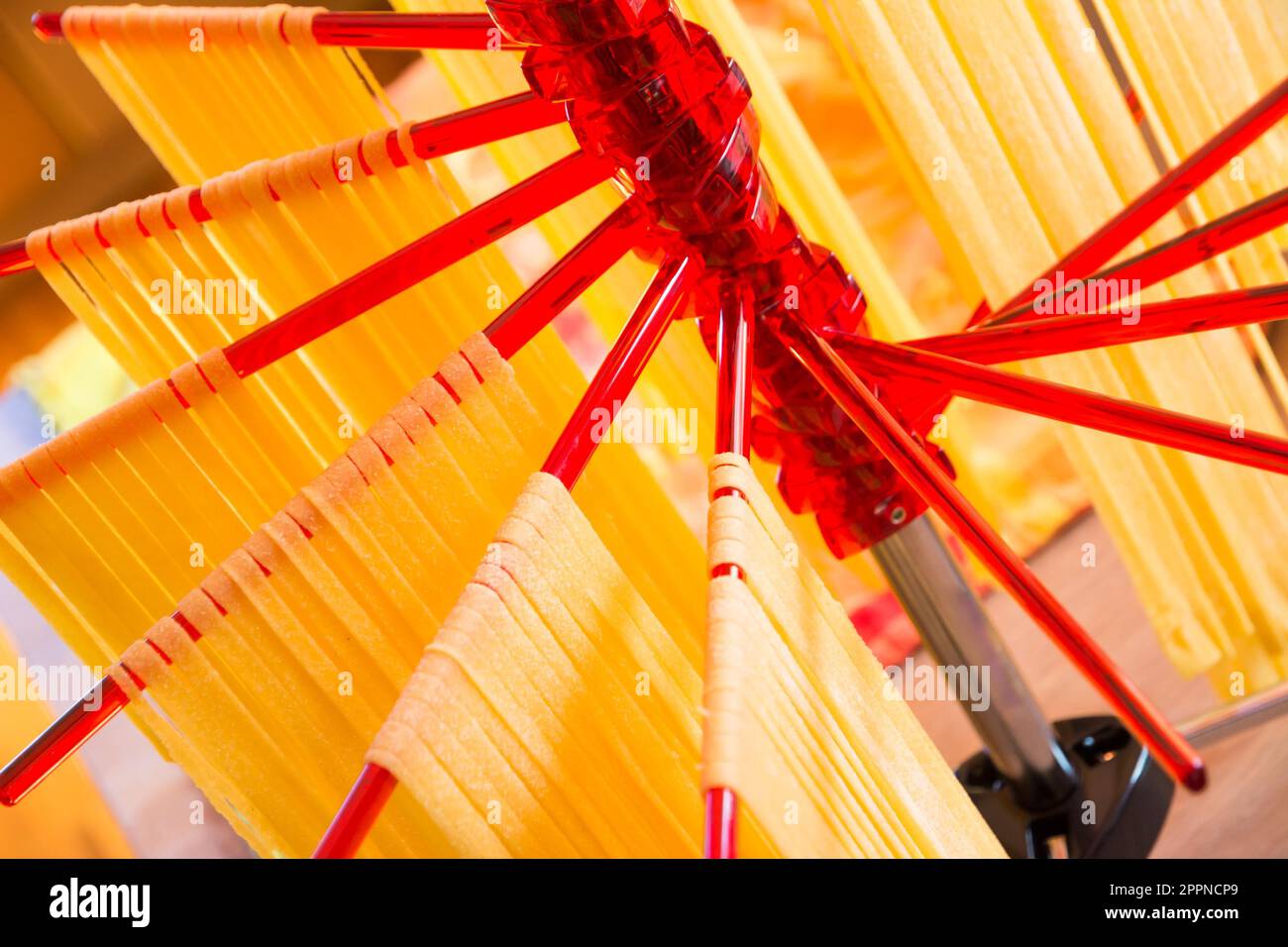 Selfmade italian tagliatelle hanging on a pasta drying rack Stock