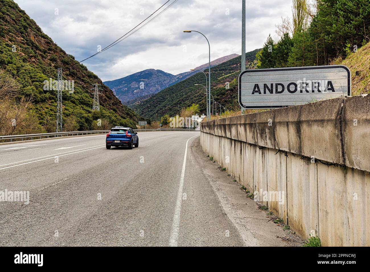 Single car on wide road at border, sign with inscription Andorra, dreary weather, Andorra Stock Photo