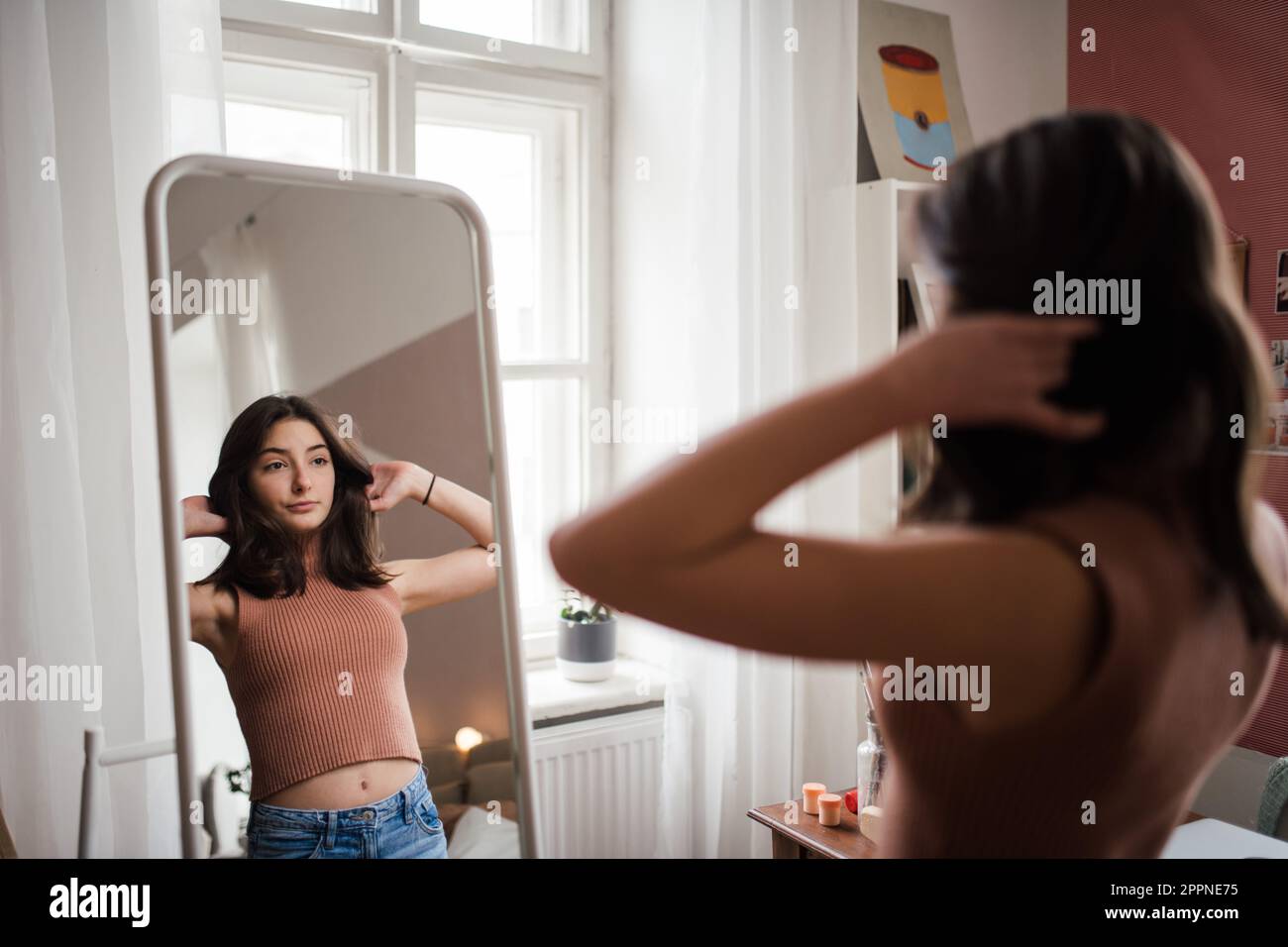 Young teenage girl looking in the mirror in her room Stock Photo - Alamy