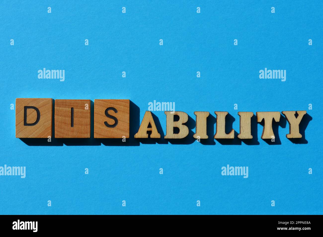 Disability, Ability, word in wooden alphabet letters isolated on blue background Stock Photo