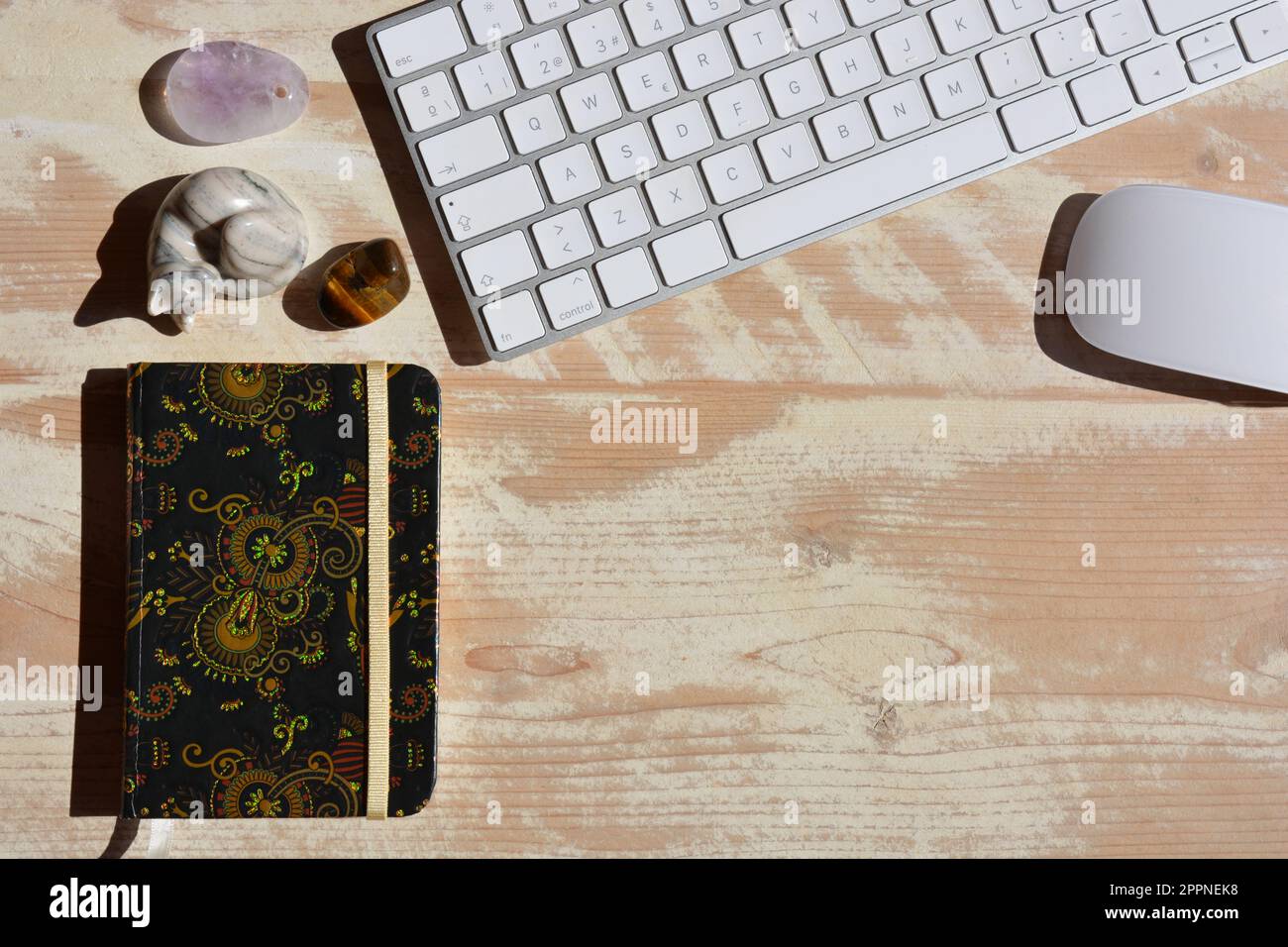Desktop flat lay showing generic keyboard, mouse, notebook and ornaments with space for copy Stock Photo