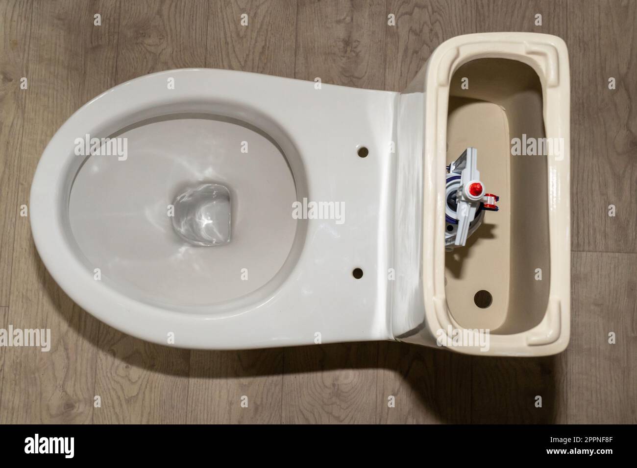 white toilet tank with an open lid and flush system. Plastic toilet drain system Stock Photo