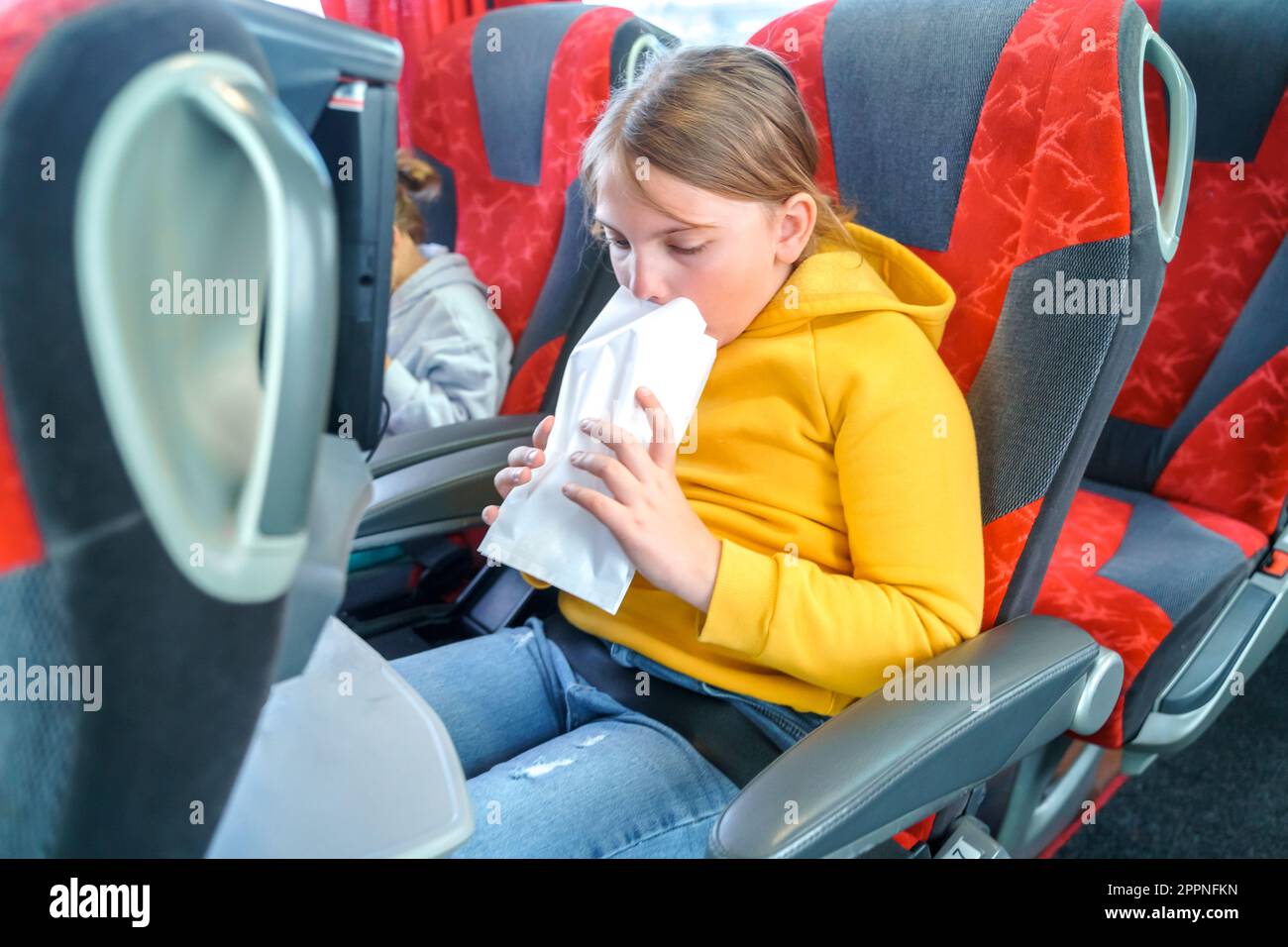 Girl is sick, vomits in bag. Bus road traveling. Girl kid feels bad