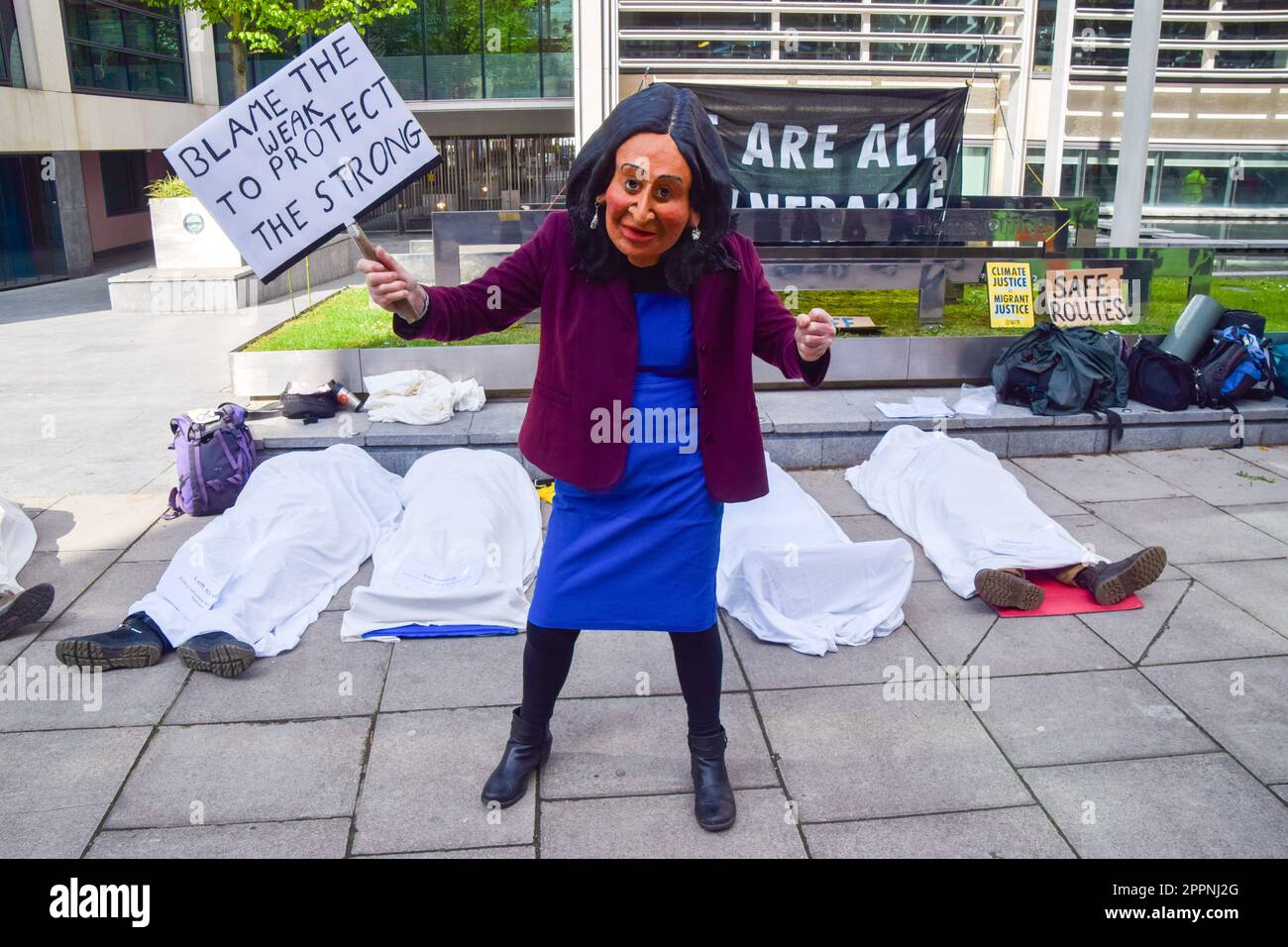 London, UK. 24th April 2023. An activist dressed as Home Secretary Suella Braverman stands next to other activists posing as dead bodies of migrants and people in developing countries affected by climate change outside the Home Office on the fourth and final day of Extinction Rebellion's protests in Westminster. Credit: Vuk Valcic/Alamy Live News Stock Photo